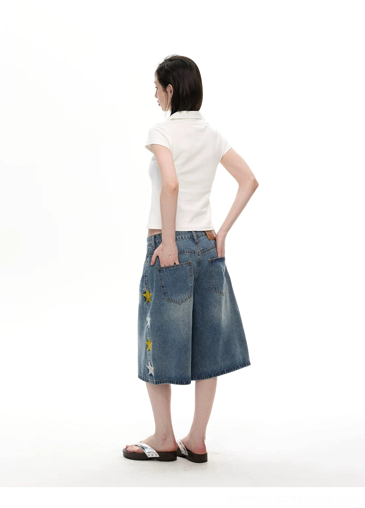 Back view of light blue wide-leg denim knee shorts showing relaxed baggy fit and classic rear pockets