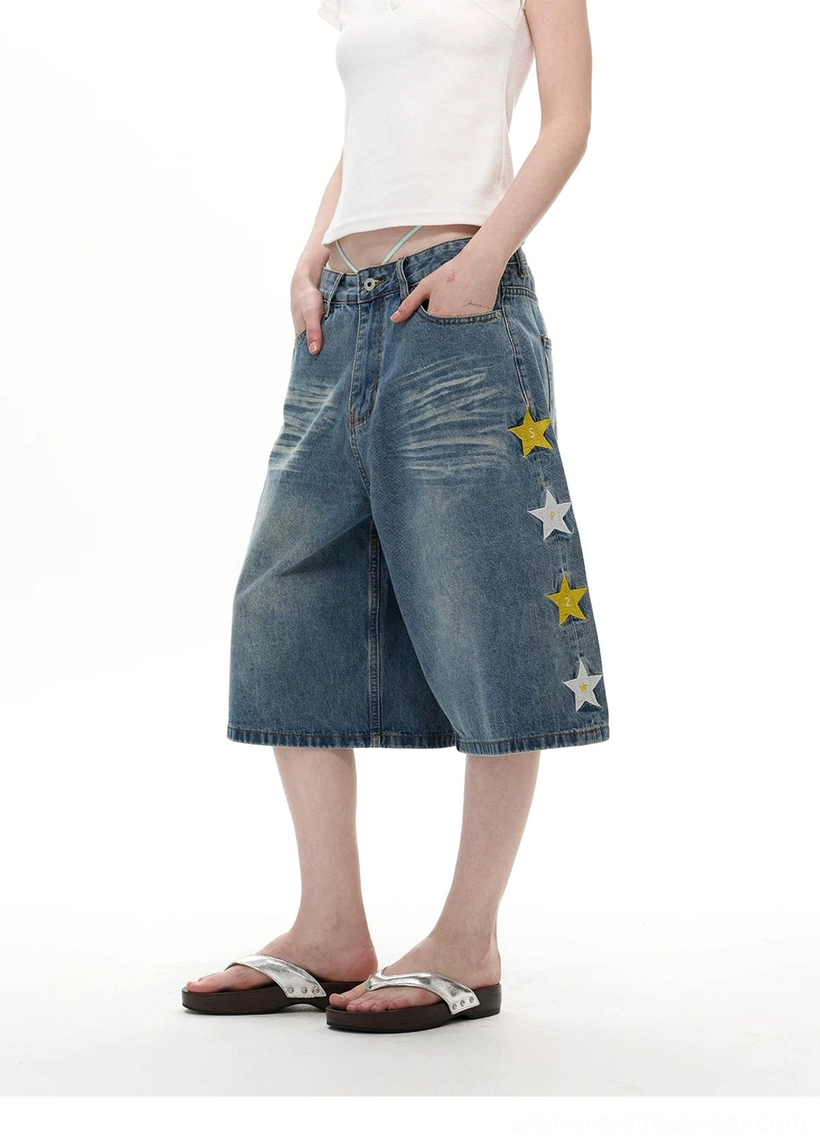 Side view of light blue star appliqué wide-leg denim knee shorts with yellow and white star details