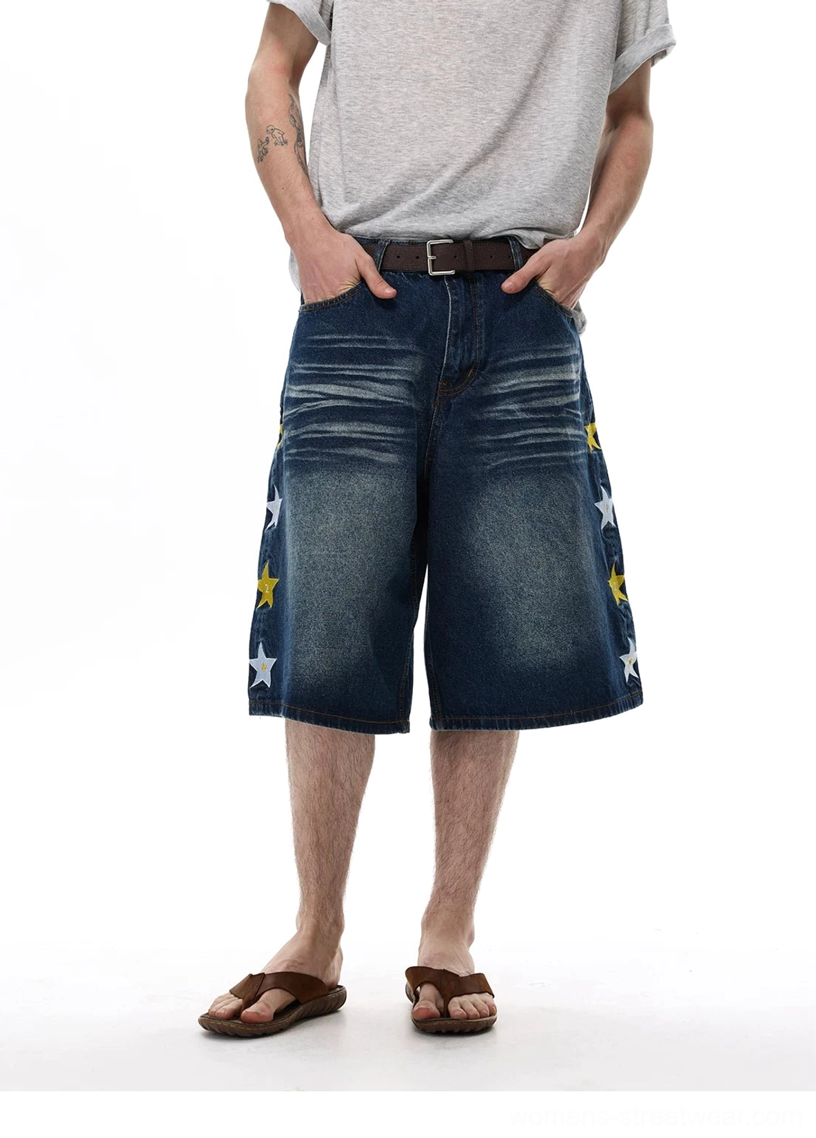 Detailed view of star appliqué wide-leg denim knee shorts with vintage washed cotton denim texture