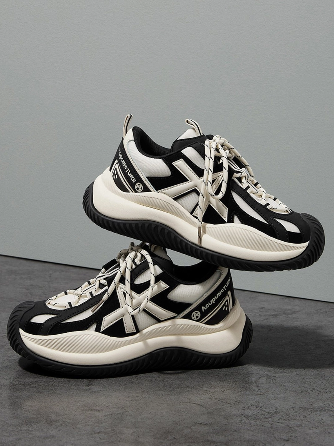 Stacked arrangement of chunky sneakers displaying consistent cross decorative pattern and thick platform sole construction