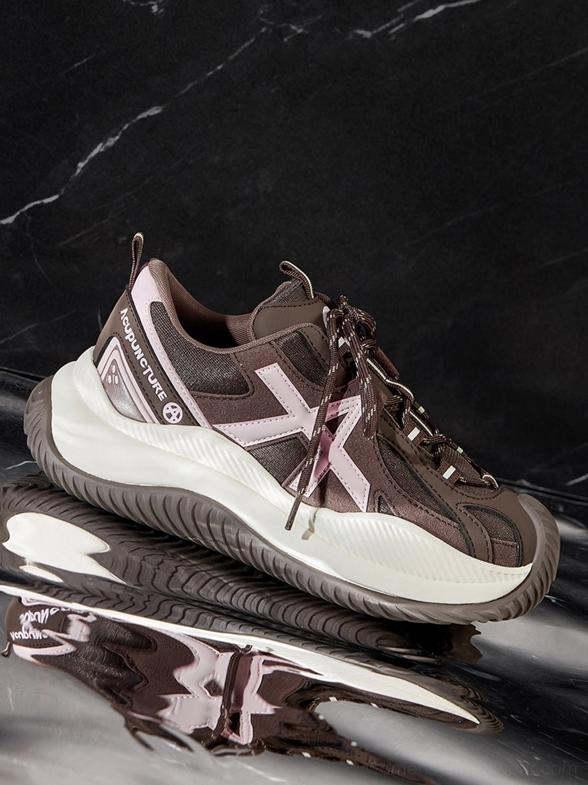 Toe box detail of chunky sneakers showing cross-shaped upper decoration geometric design reinforced construction