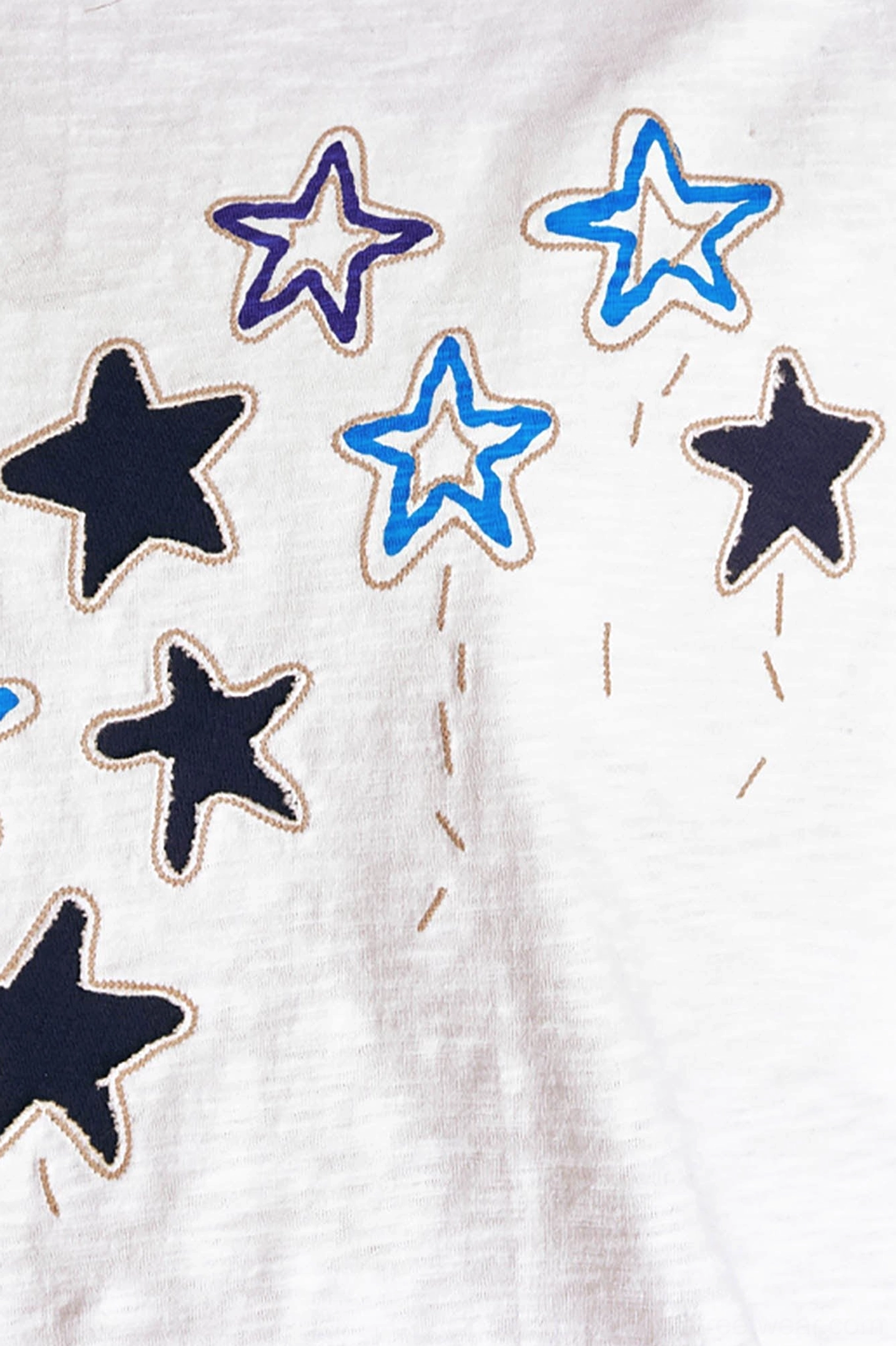 Detailed close up of stitched star parade chest motif on soft textured white cotton graphic streetwear t-shirt