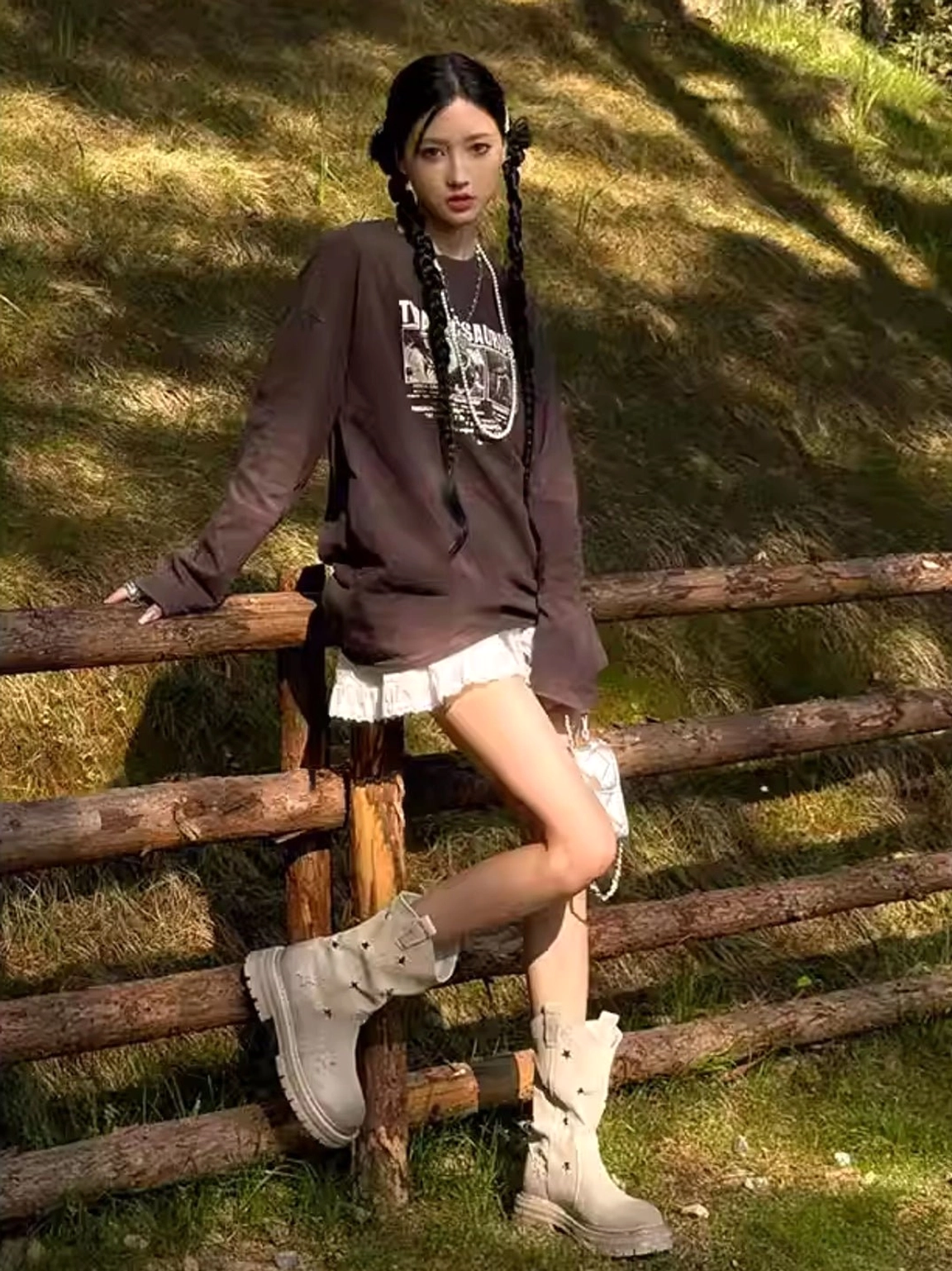 Star platform cowboy boots full-body outdoor side view with model in Y2K casual street style against grassy background with wooden fence