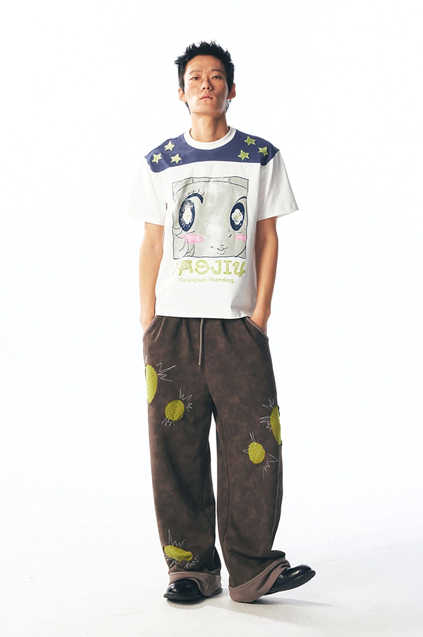 Male model front view wearing white star shoulder cartoon graphic unisex streetwear tee