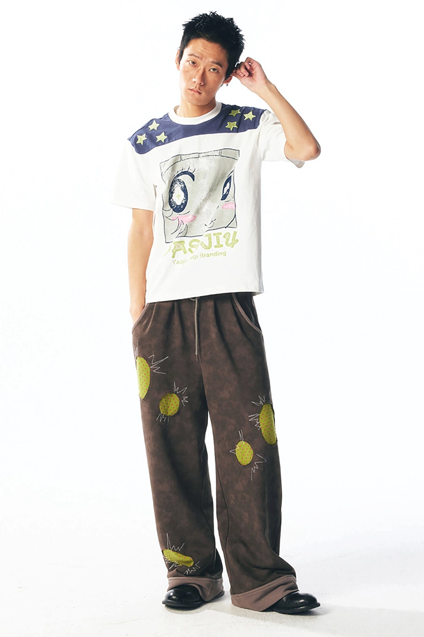 Male model side view showing navy yellow star shoulder detail on cartoon graphic streetwear tee