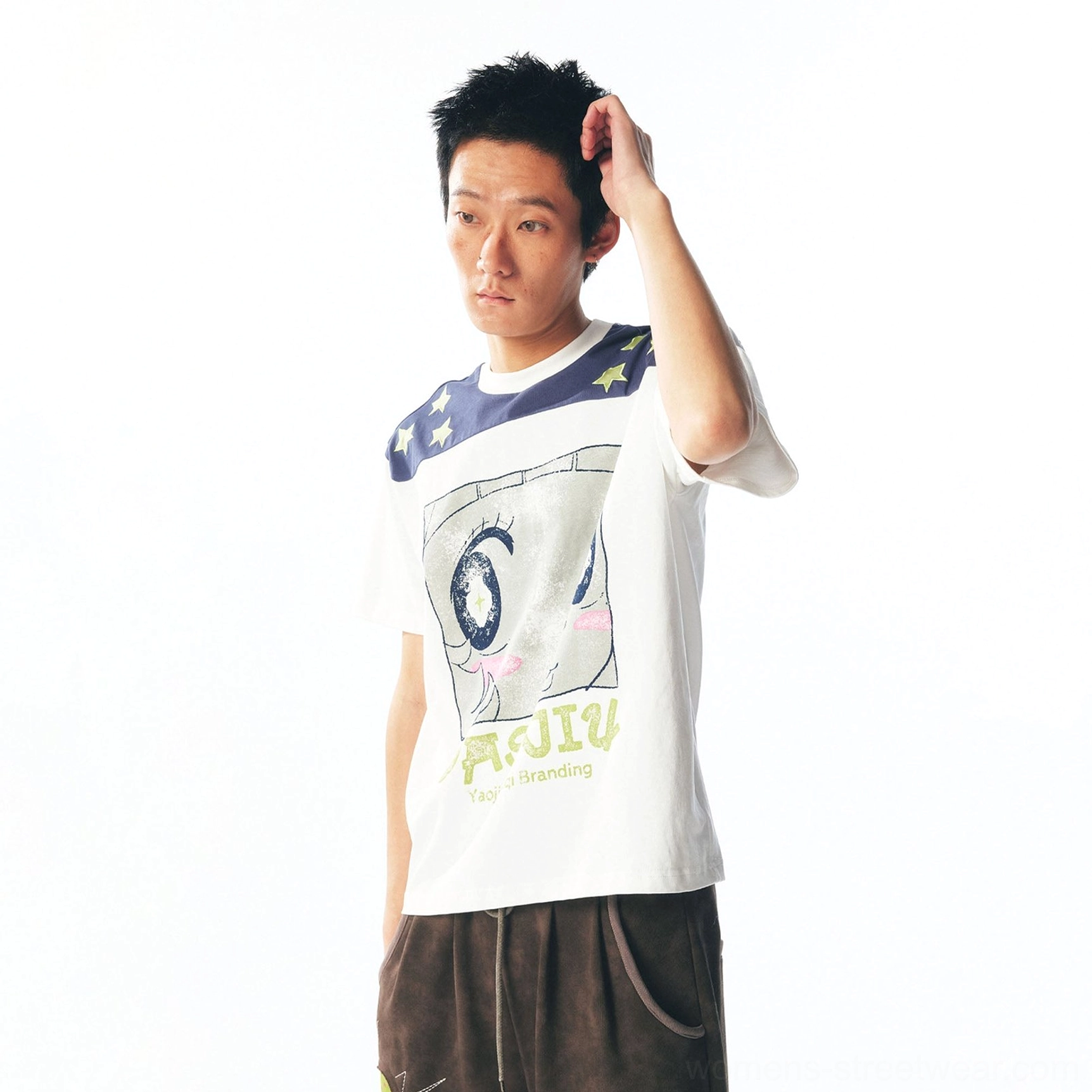 Three-quarter view of male model in white cartoon graphic tee with contrast navy star shoulders