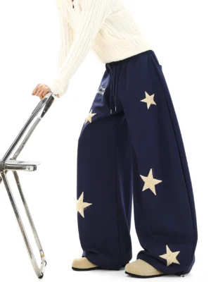 Navy blue starlit dream ultra wide streetwear sweatpants with cream textured star patches shown in side back view