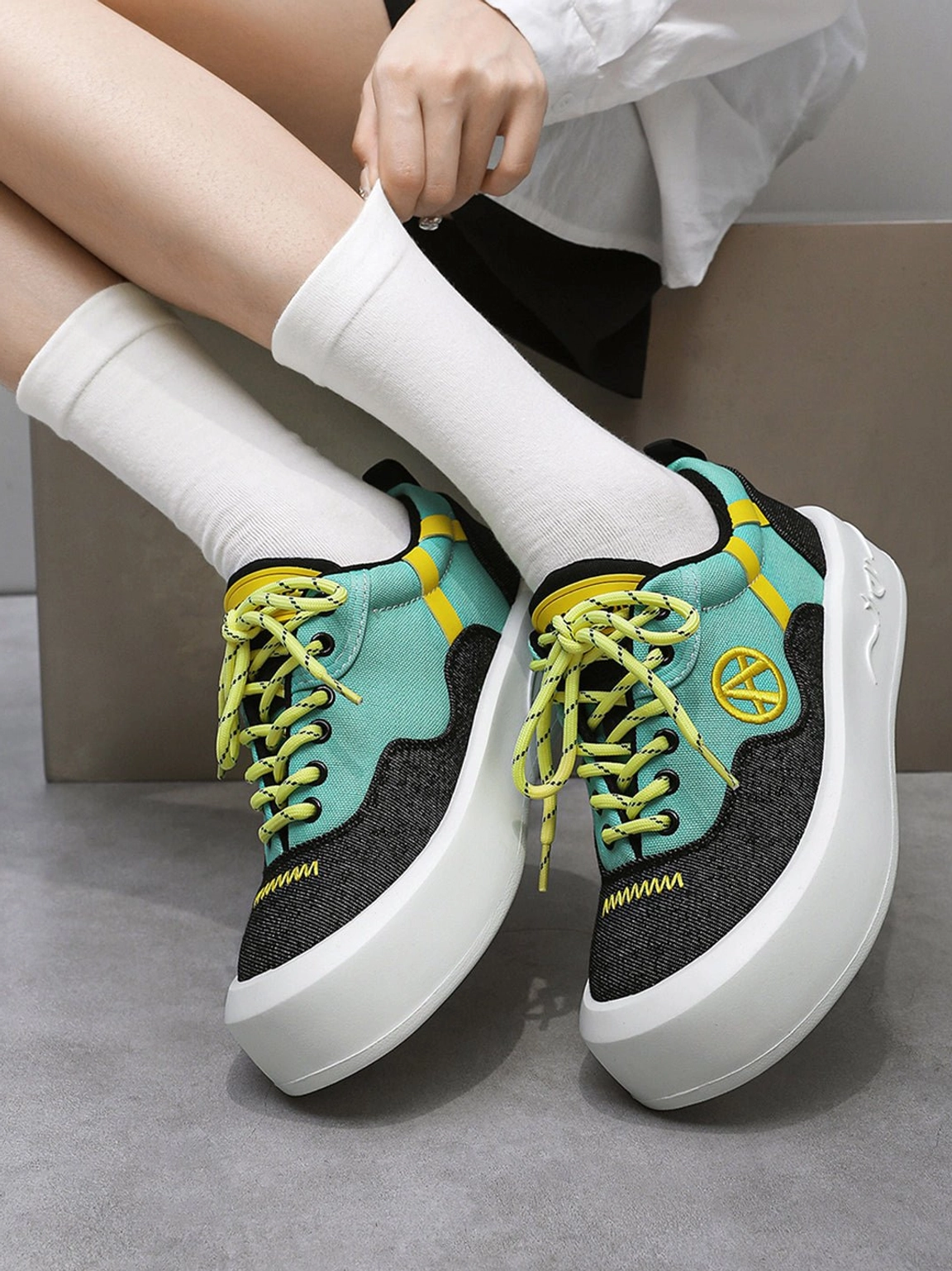 Statement neon sneakers featuring contrasting panels playful proportions and a clean chunky white sole