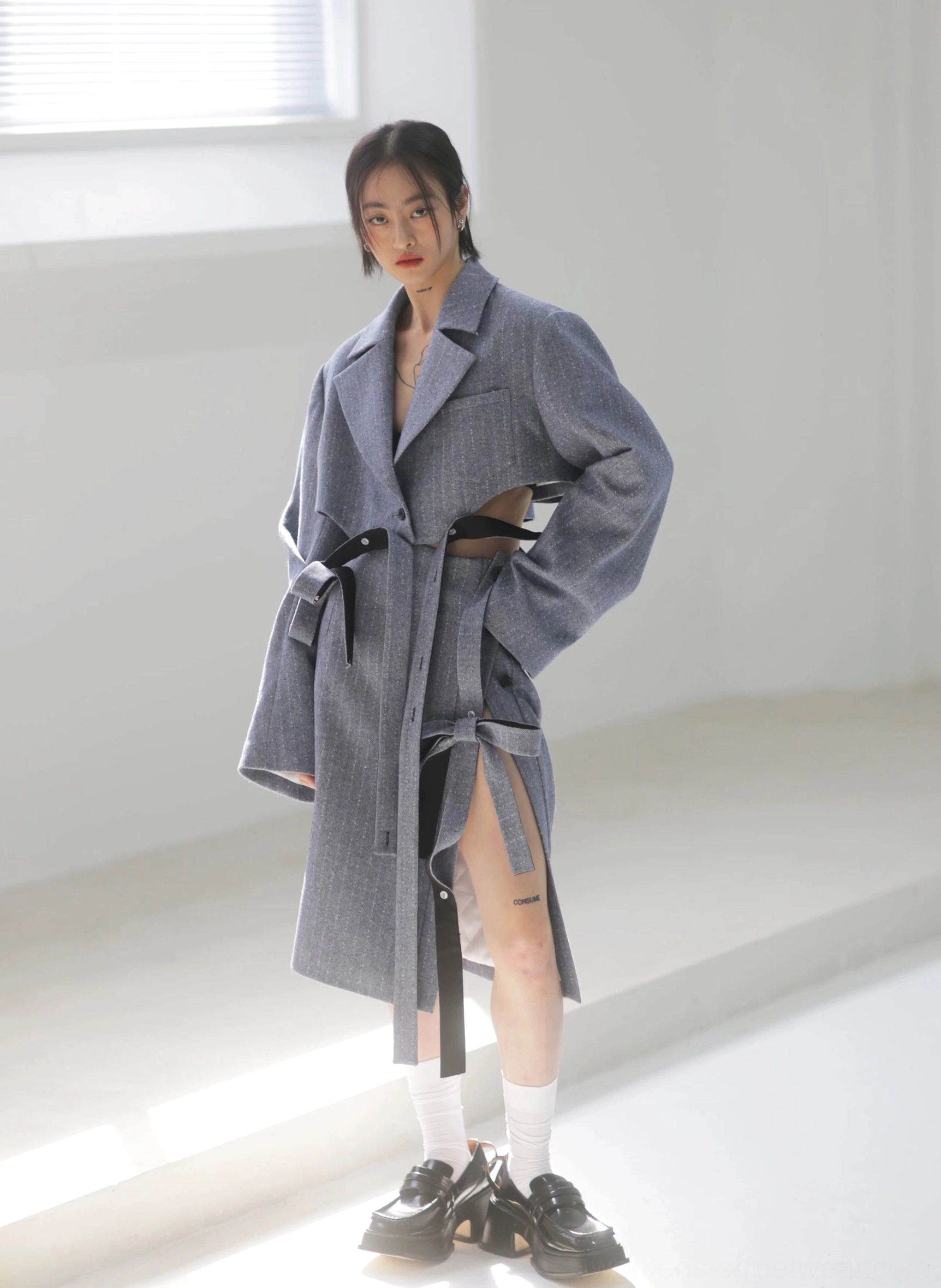 Steel blue herringbone pencil midi skirt worn with a notched lapel tailored coat, featuring a side slit, ribbon tie, and contemporary Korean fashion silhouette