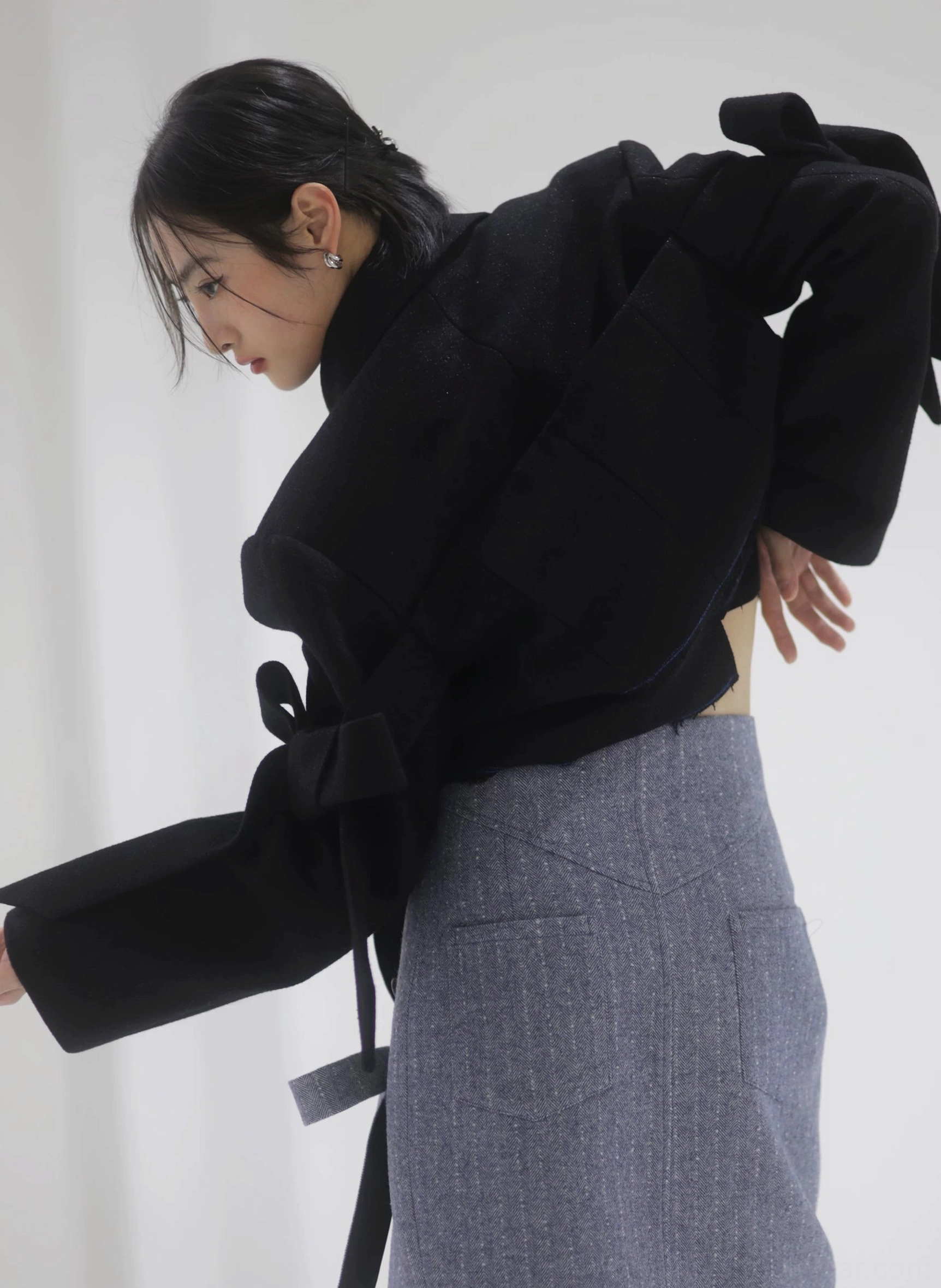 Steel blue herringbone pencil midi skirt in tailored streetwear styling, showing the refined suiting texture, high-waisted fit, and sleek midi silhouette