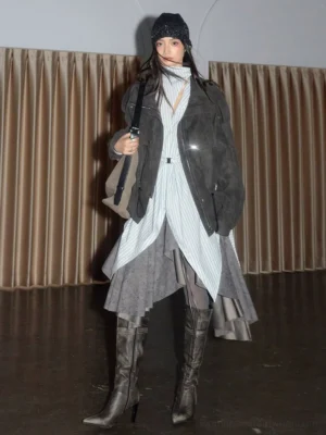 Storm grey convertible faux suede utility jacket styled in a front three-quarter studio look with layered skirt and heeled boots
