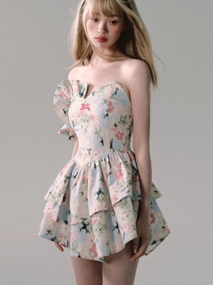 Front view of a strapless white floral ruffle mini dress with sweetheart neckline, pastel flower print, double-layer skirt, and flared silhouette