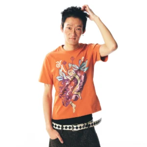 Orange strawberry fairy graphic cropped baby tee styled with low-rise wide-leg pants and a geometric statement belt