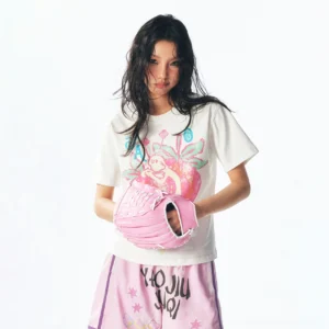 White strawberry fairy graphic cropped baby tee styled with pink printed shorts and a playful streetwear baseball accessory