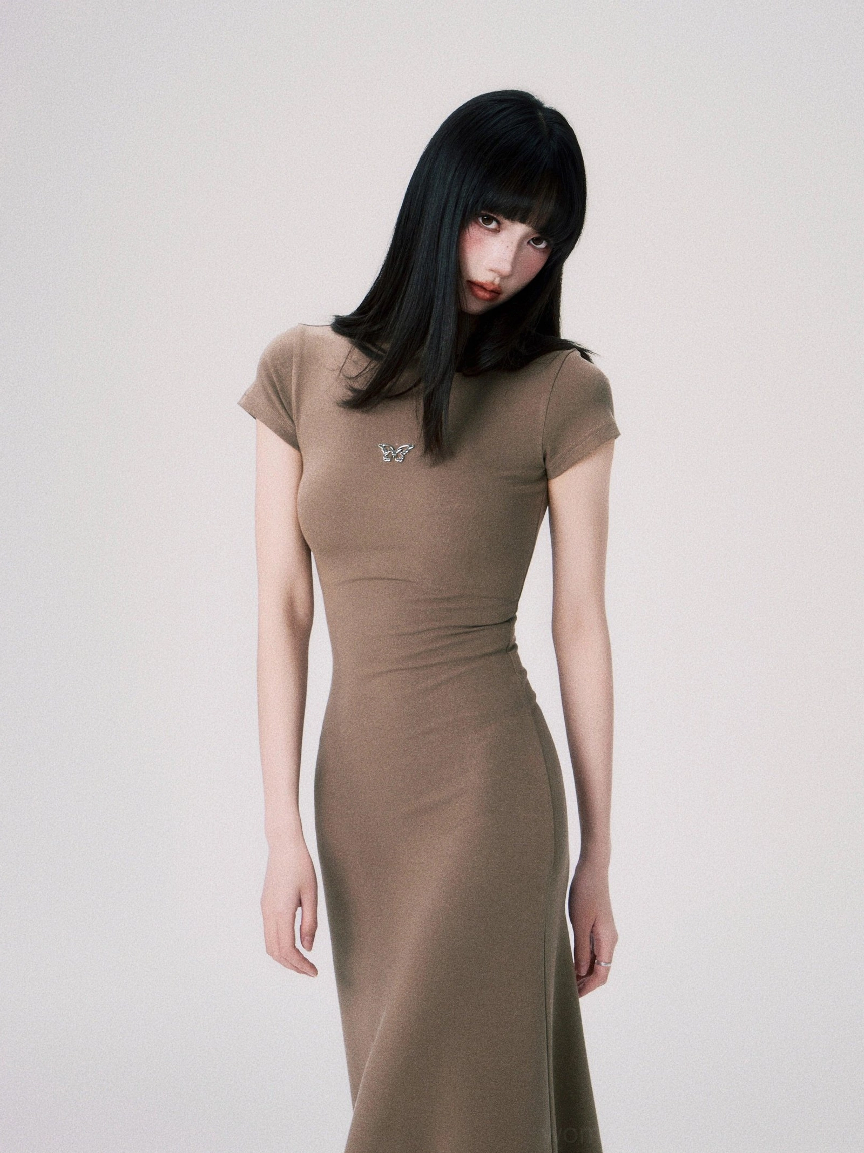 Stretch knit butterfly emblem dress with short sleeves mock neck and figure flattering floor length design