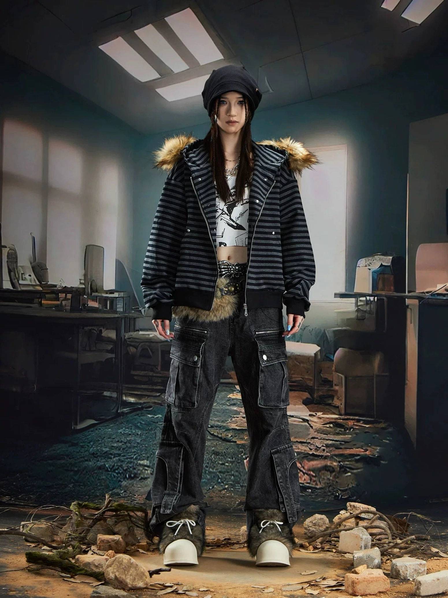 Female model wearing a striped faux fur hooded zip jacket with a knit beanie, split-hem cargo jeans, and casual sneakers