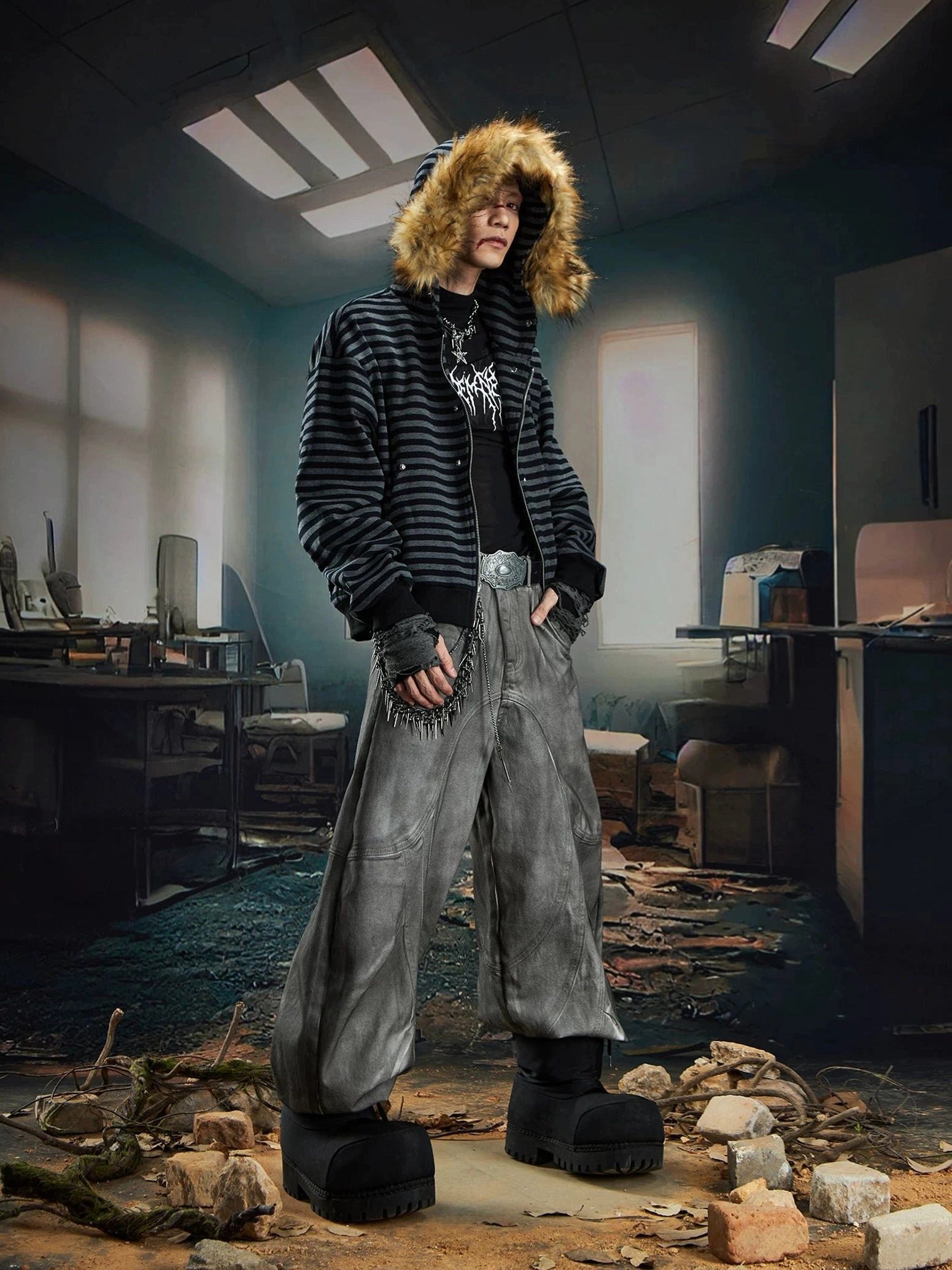 Side view of a male model wearing a relaxed striped faux fur hooded zip jacket with washed grey wide-leg pants and platform boots