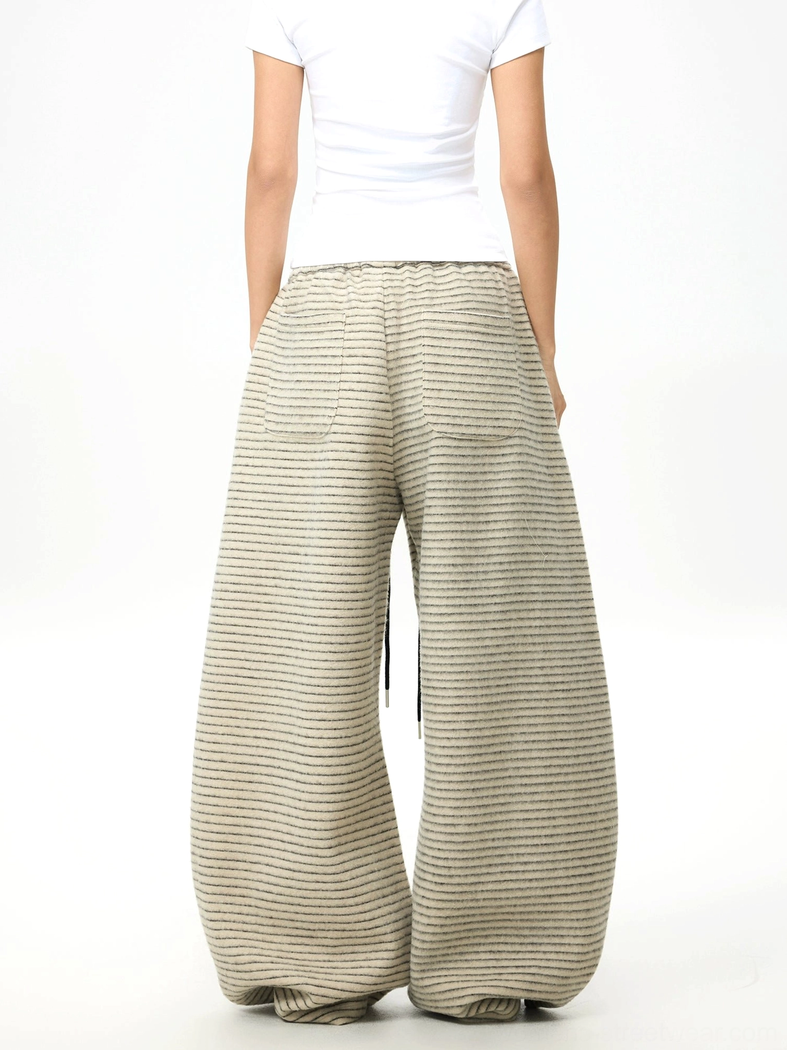 Back view of horizontal striped fleece wide-leg pants with elastic drawstring waistband and relaxed oversized silhouette