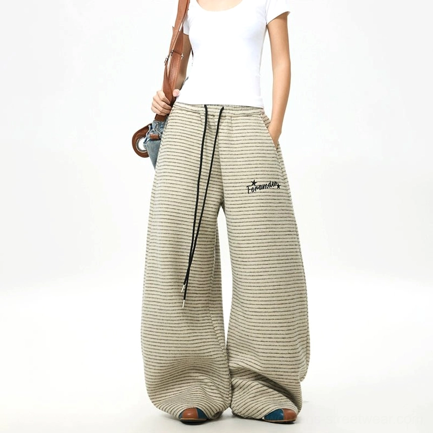 Right three-quarter view of striped fleece wide-leg streetwear pants with oversized legs, drawstring waist, and embroidered thigh detail
