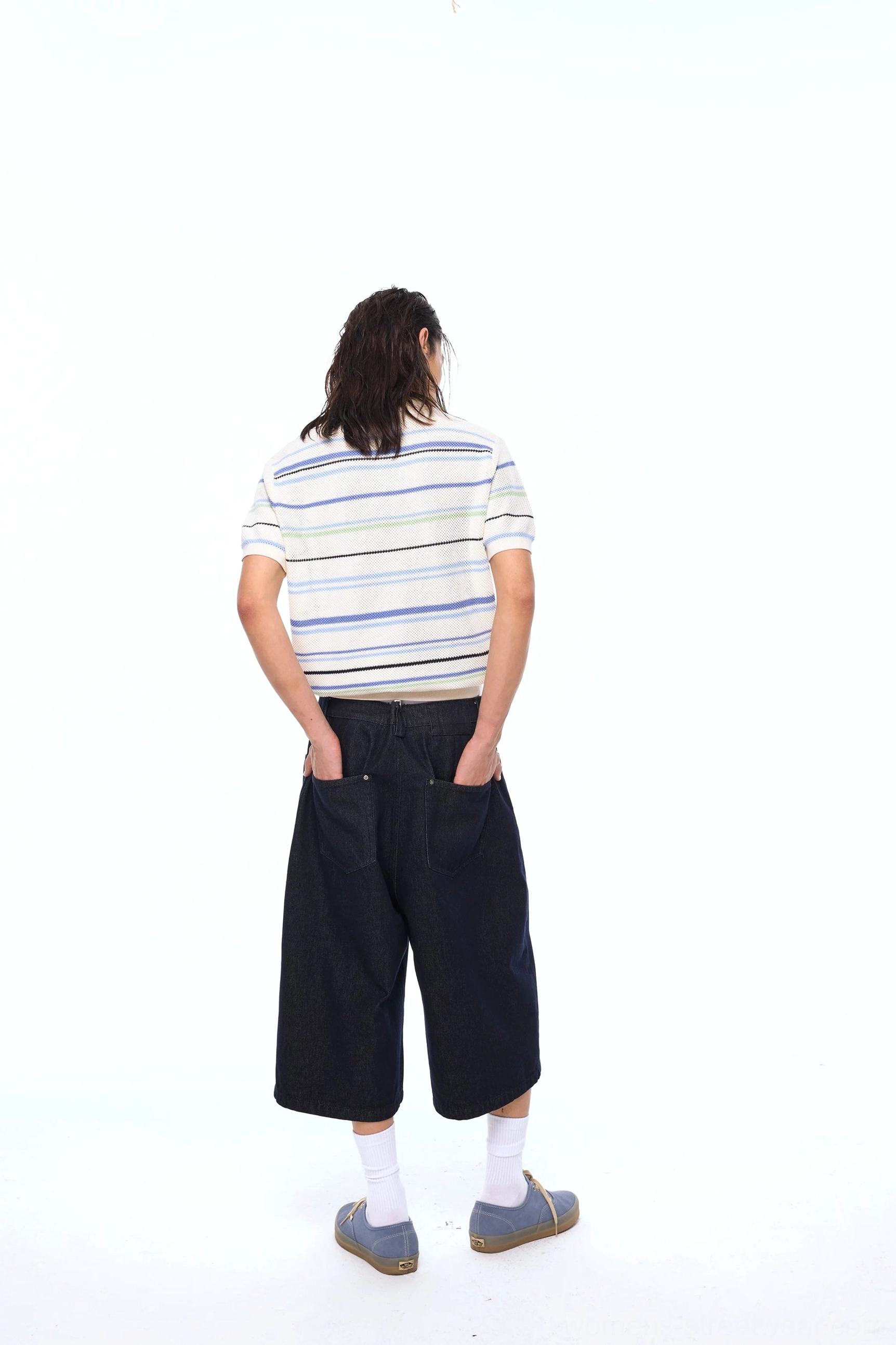 Back view of a relaxed striped openwork knit polo shirt paired with cropped wide-leg denim, white socks, and loafers in a modern streetwear outfit