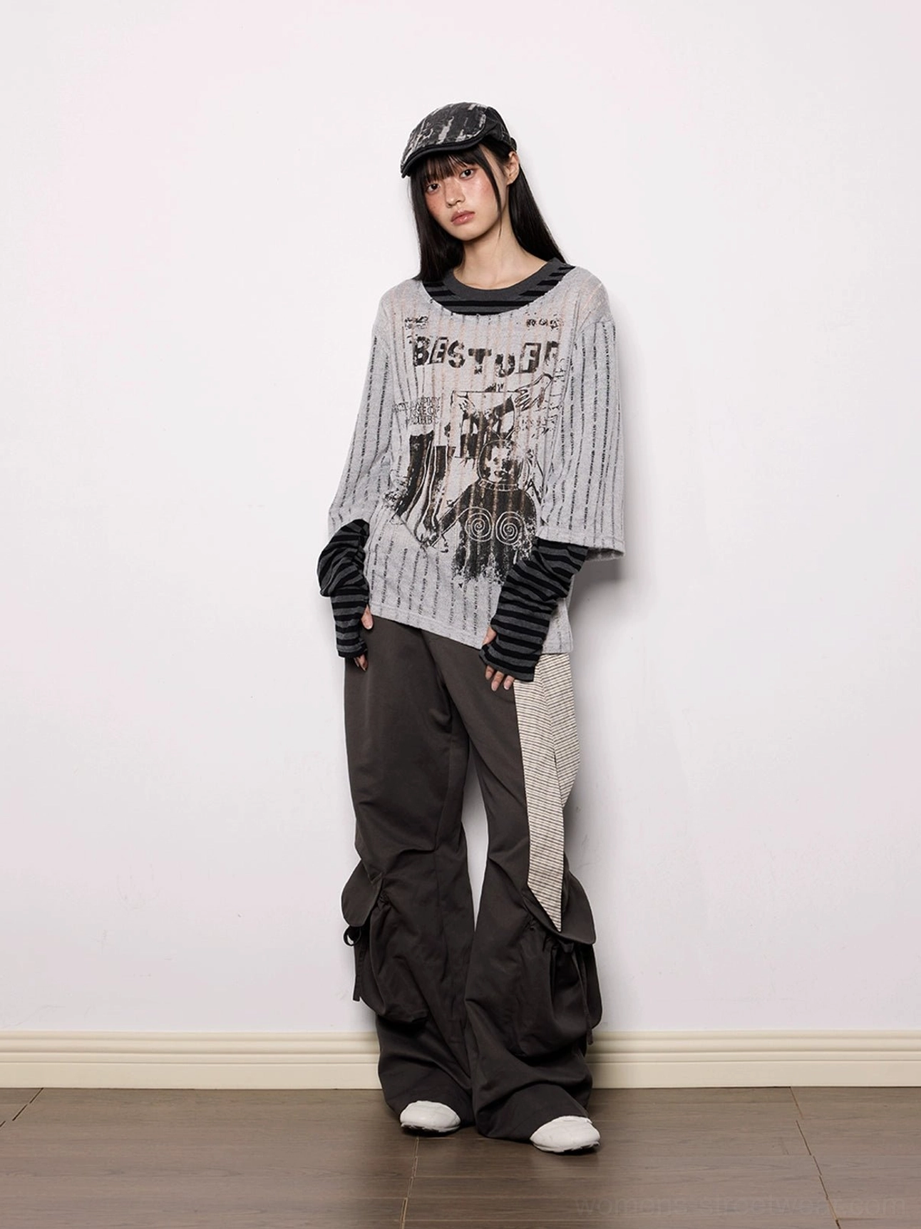 Dark gray wide-leg streetwear cargo pants with striped sash belt styled in a full-body front studio outfit