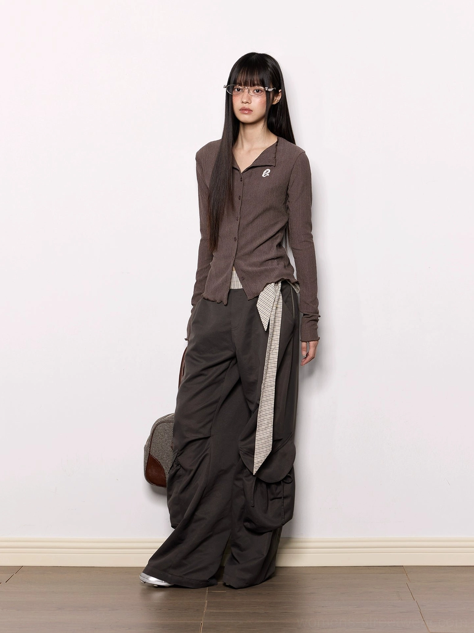 Dark gray wide-leg cargo pants with oversized side pockets and striped wrap sash belt shown from a side-front view