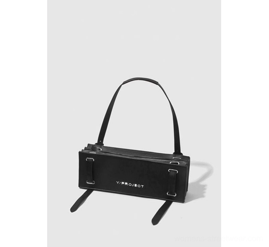 Front three-quarter view of a structured black rectangular shoulder bag with silver hardware, smooth finish, long shoulder strap, and dangling strap details