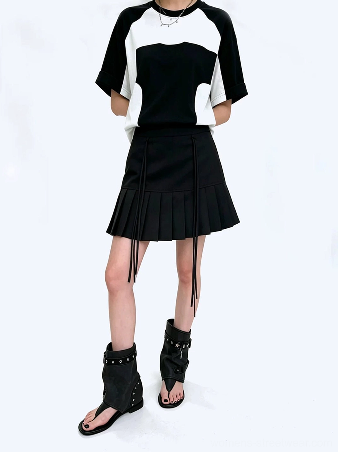 Full outfit styling with studded buckle thong ankle boot sandals, raglan tee, and pleated skirt