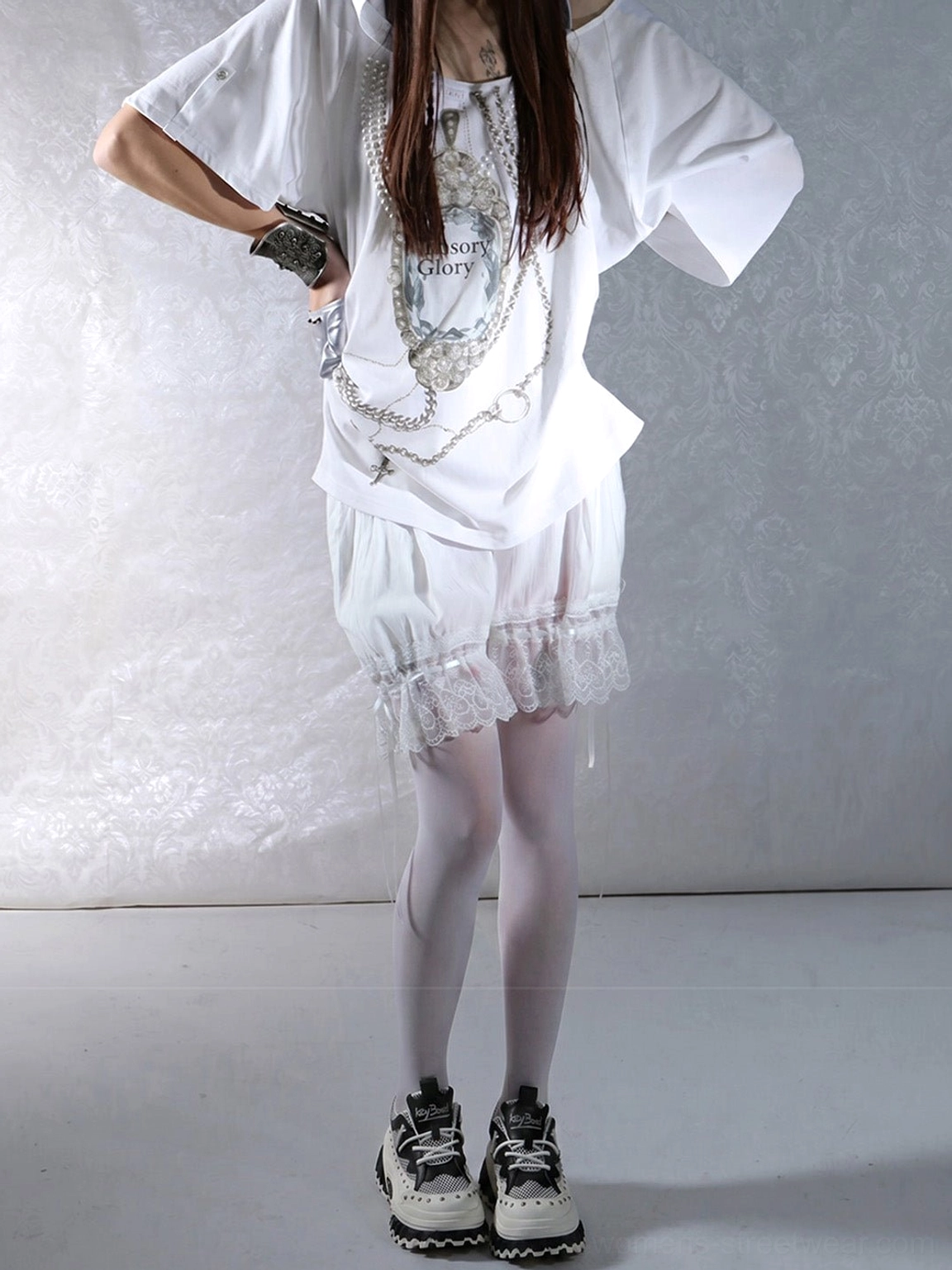 Side view of black and white women’s platform loafers paired with a mini skirt, sheer tights, and oversized streetwear