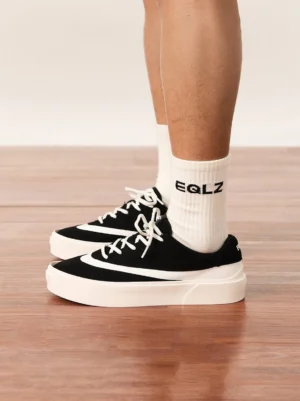 Black and white colorblock platform sneakers worn with crew socks in a front close-up streetwear outfit
