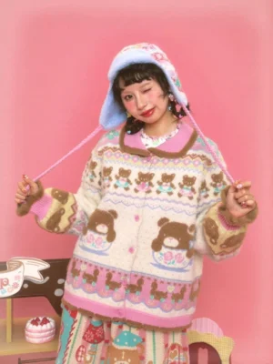 Sweet Bear Tea Party ivory knit cardigan with teddy bear and teacup Fair Isle motifs, pink trim, fuzzy cuffs, and matching bonnet styled in a pastel café setting