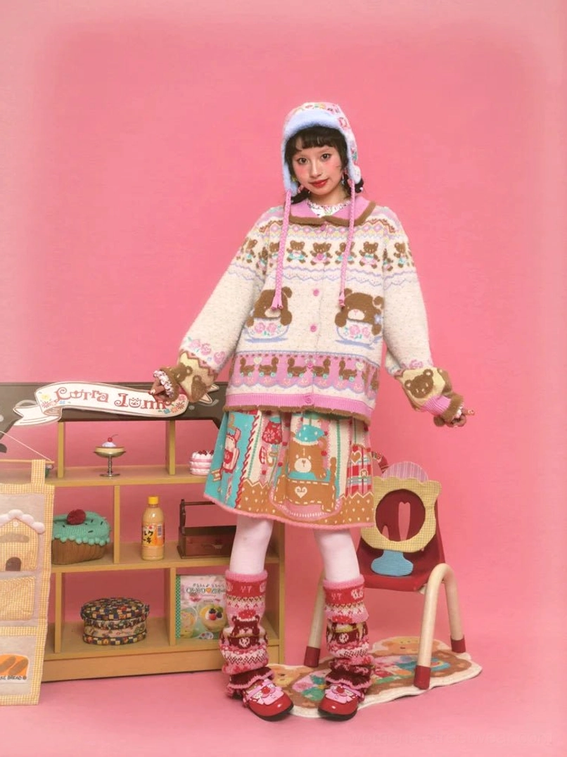 Coordinated Sweet Bear Tea Party knitwear styling with an ivory teddy bear cardigan, matching bonnet, dessert print skirt, and pastel accessories