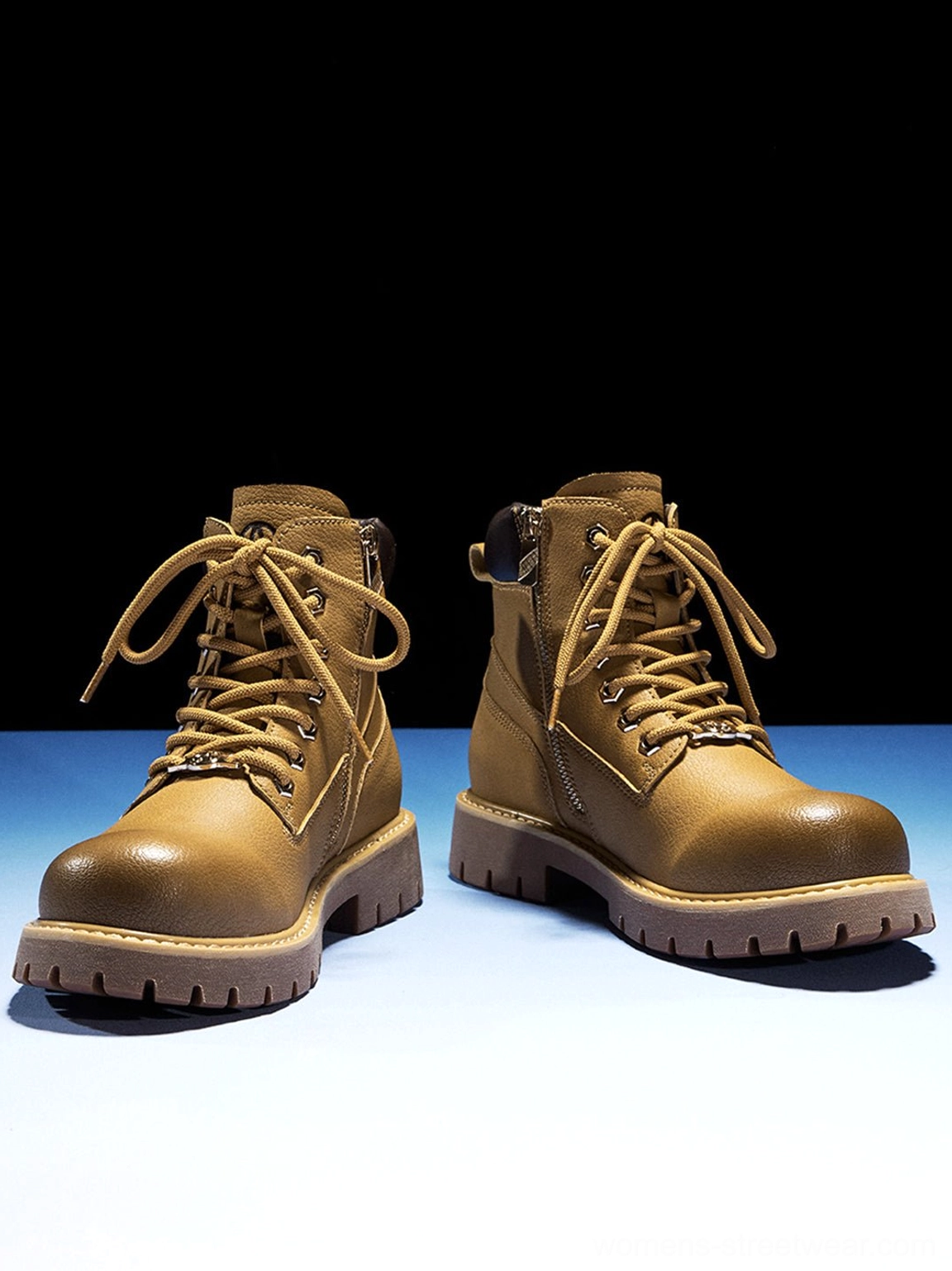 Tilted dynamic static shot pair tactical zip-front ankle boots dark studio blue lighting lace-up design