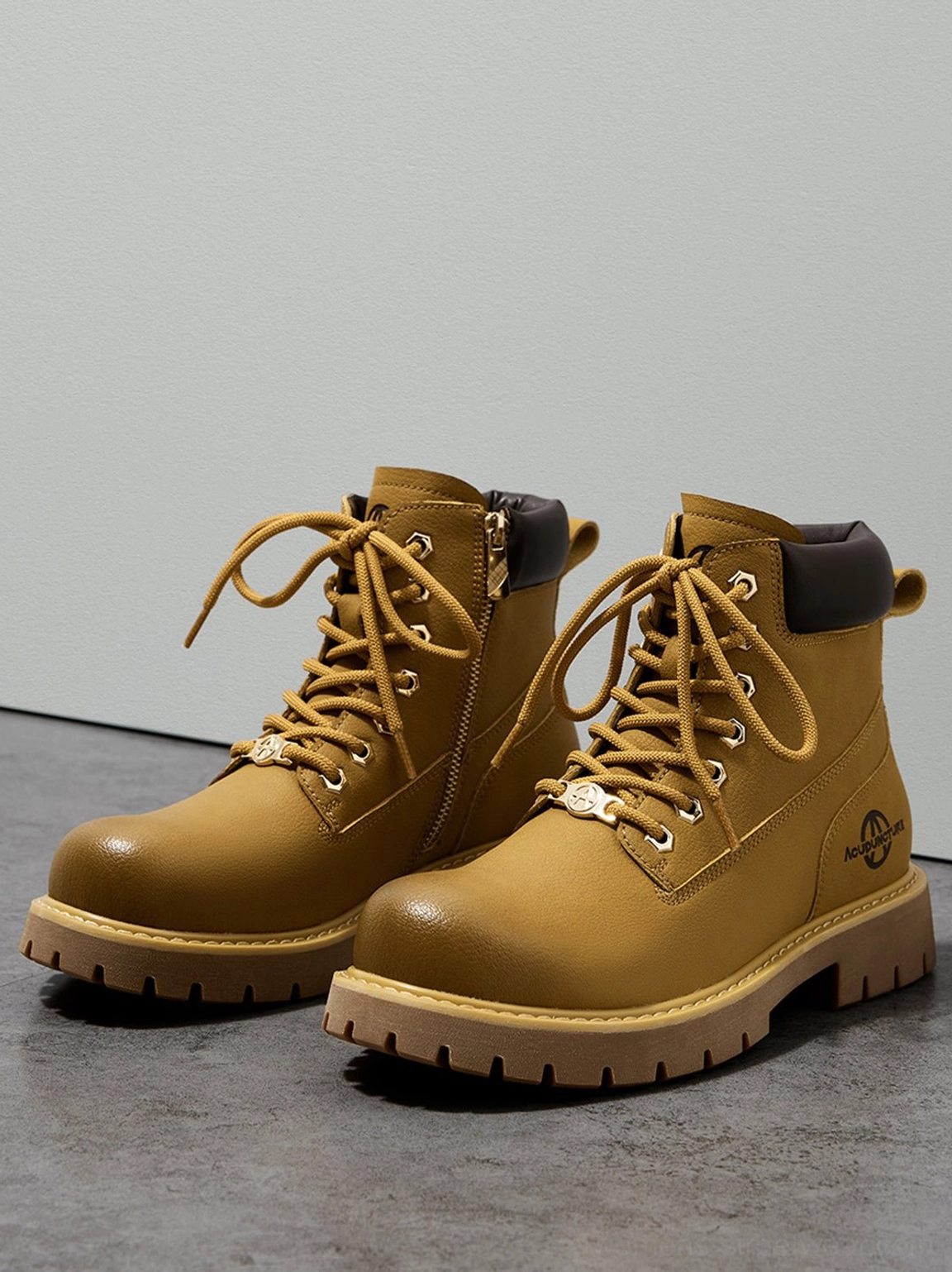 Tilted dynamic shot pair tactical zip-front ankle boots grey floor minimalist background lug soles