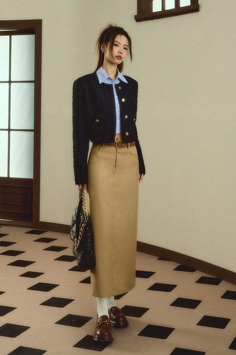 Low front view of a woman wearing a tailored khaki maxi skirt styled as a retro workwear streetwear outfit