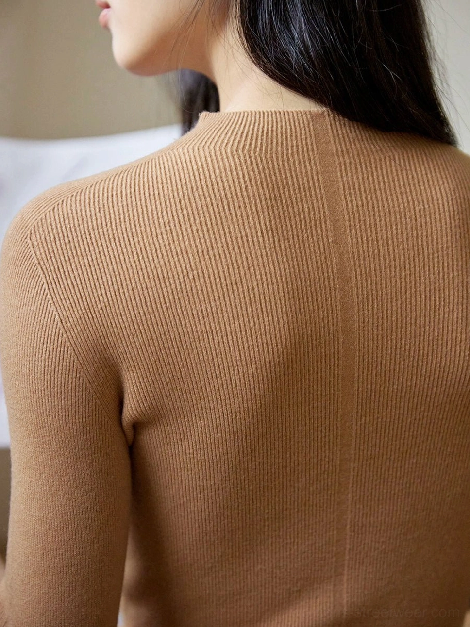 Tan brown ribbed mock neck knit sweater shown from the back with a central seam and vertical knit texture