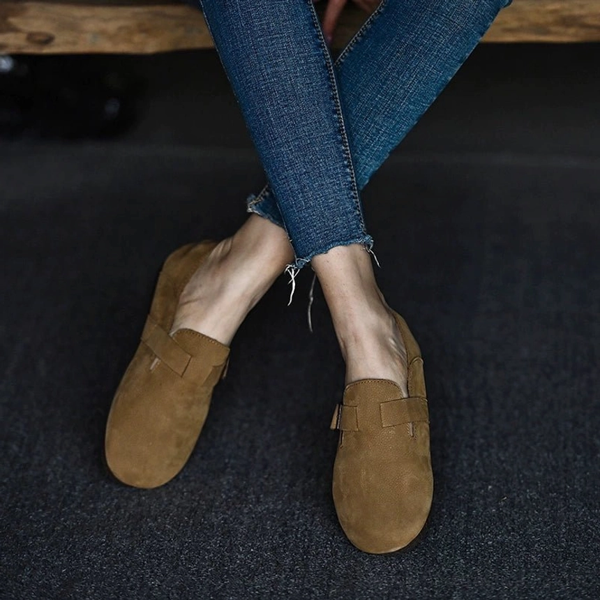 Top-down view of both tan buckle loafers worn with blue denim, showing the consistent color and neat textured leather finish