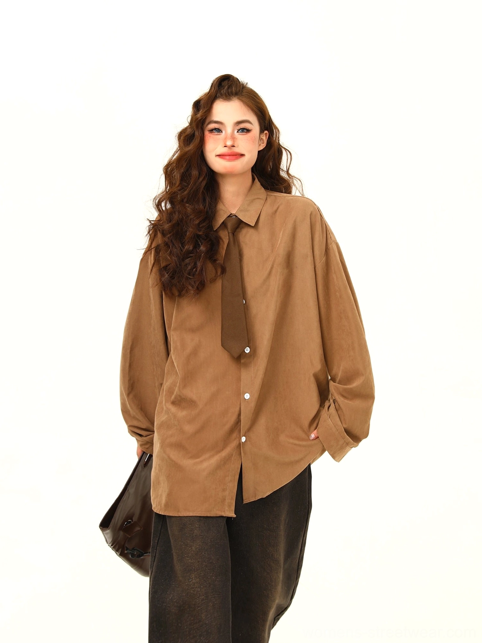 Front three-quarter view of tan oversized corduroy shirt with matching brown necktie, long sleeves, front buttons, and black wide-leg pants