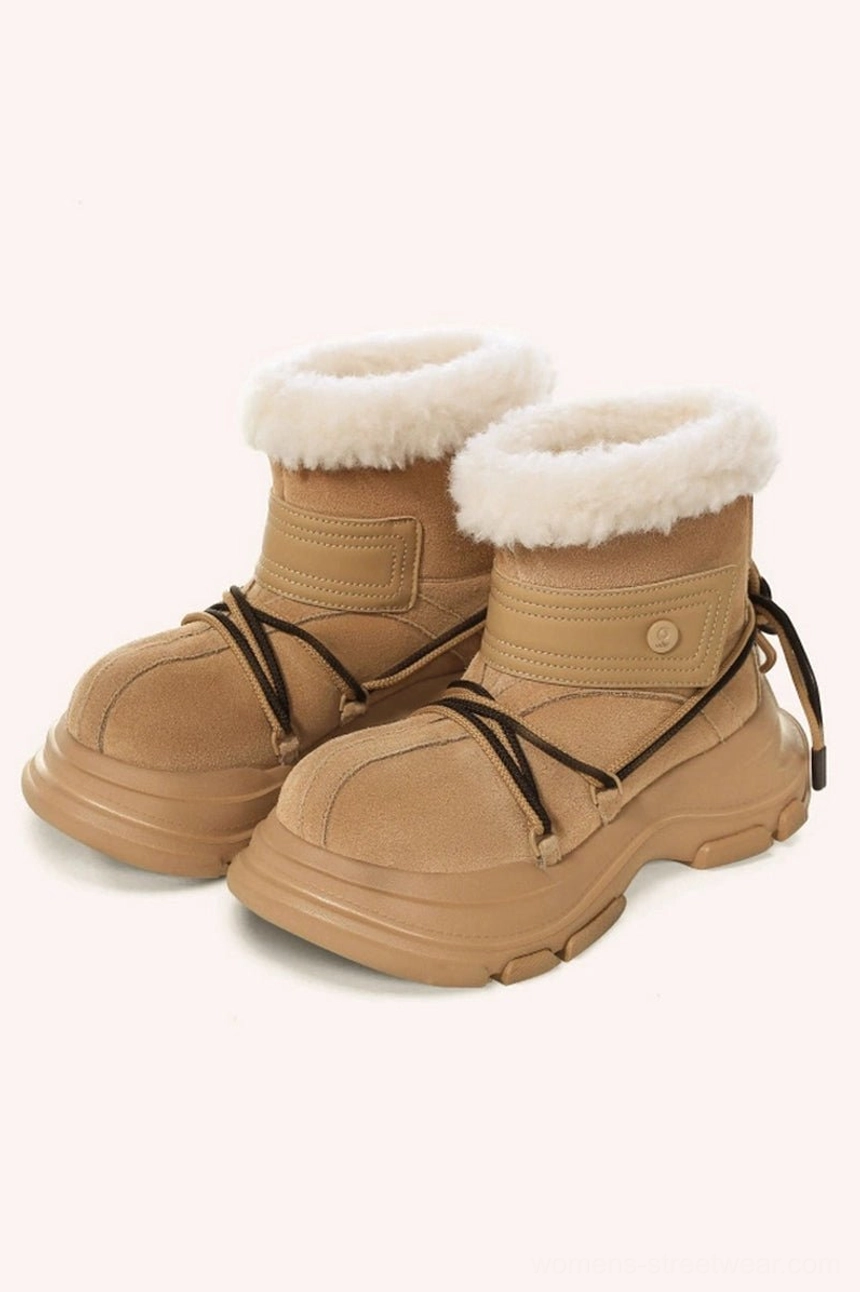 Three-quarter view of tan suede-look platform snow boots with fluffy white faux fur trim and ankle strap detail