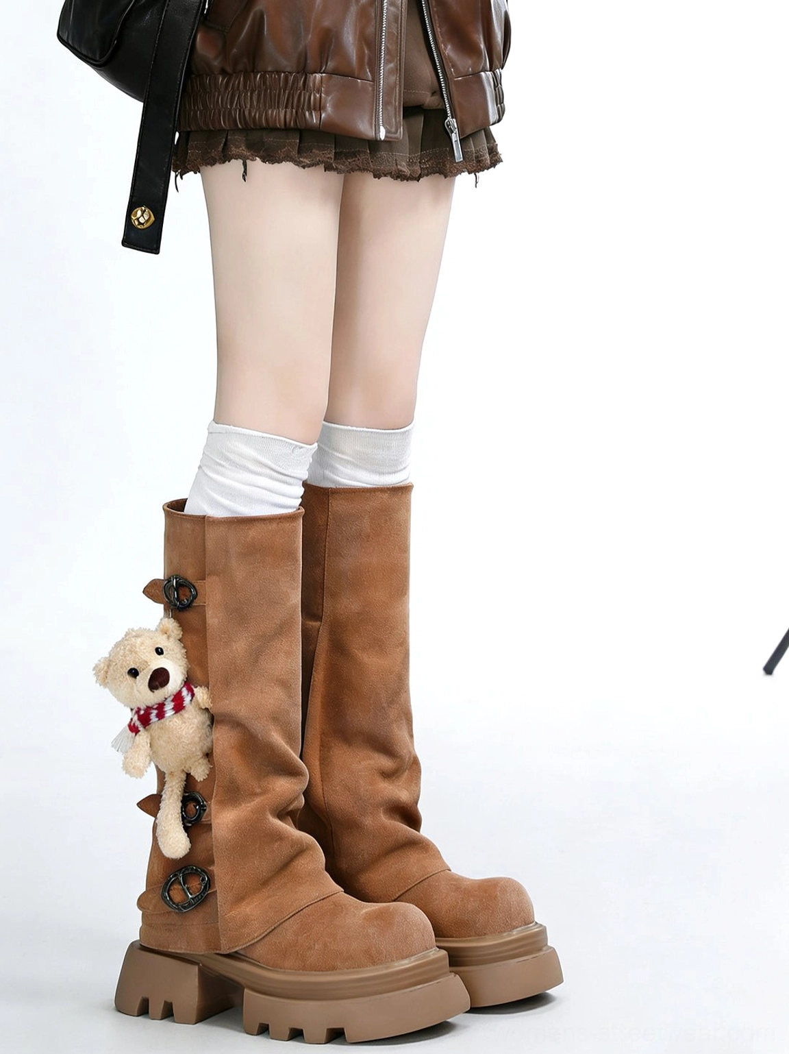 Side-back view of tan teddy bear charm chunky boots styled with a brown leather jacket and ruffled mini skirt