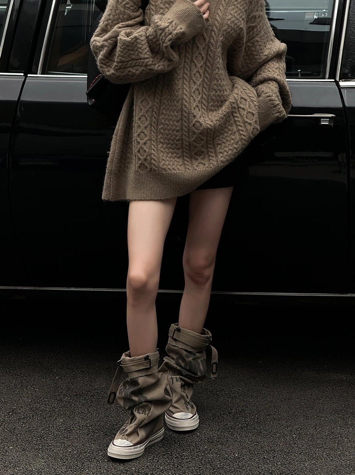 Full standing street style look featuring taupe graffiti canvas slouchy platform tall boots paired with an oversized knit sweater and shorts