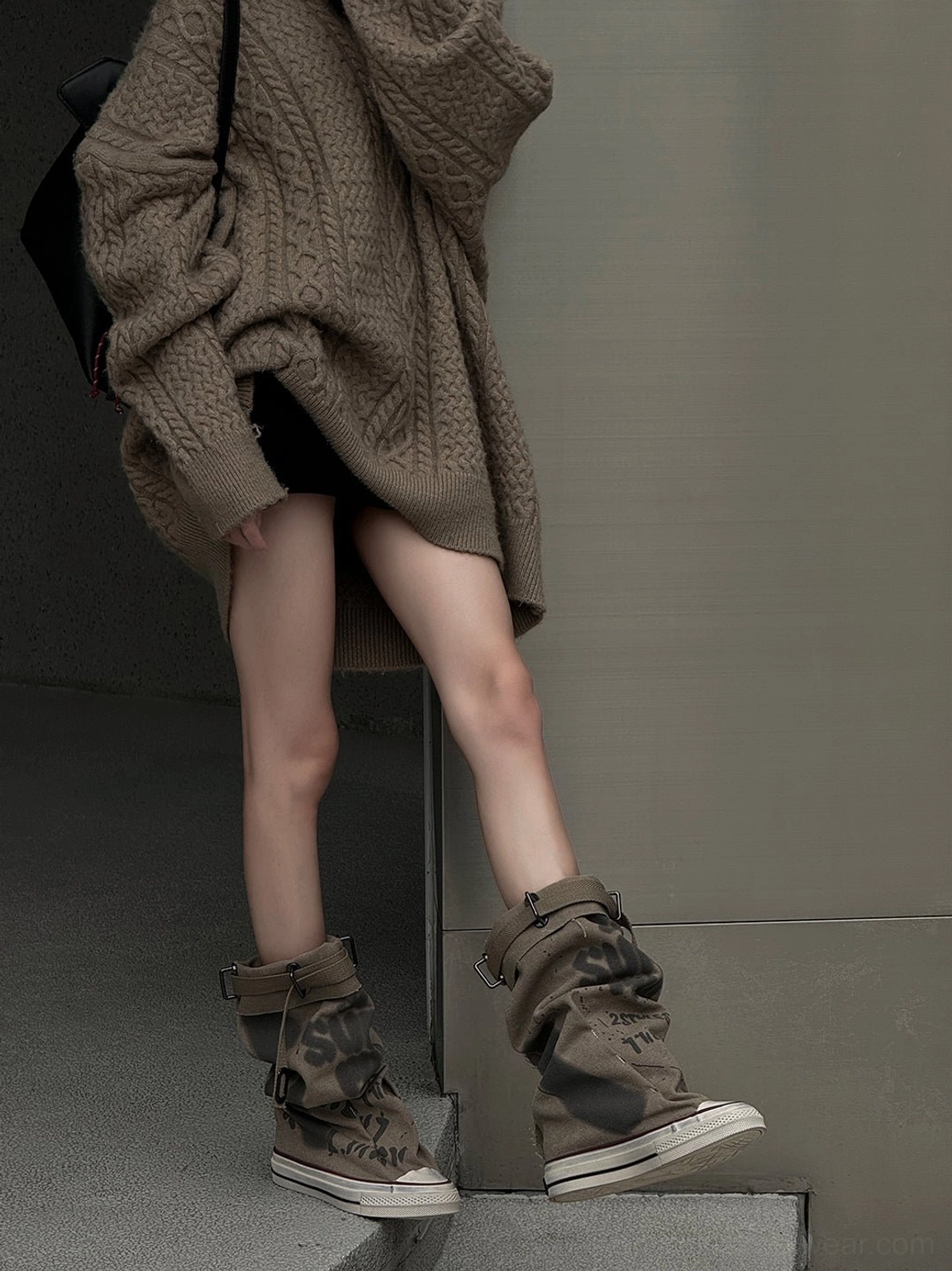 Taupe graffiti canvas platform tall boots styled with an oversized taupe knit outfit in a minimalist indoor streetwear setting