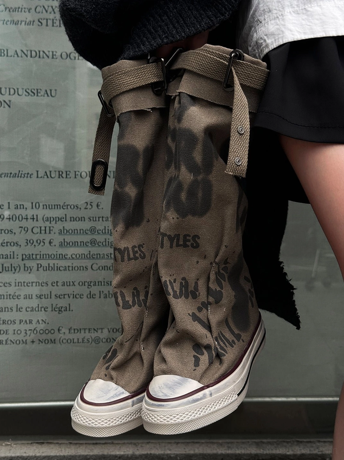 Taupe graffiti canvas slouchy platform tall boots close-up showing the faded print and rugged rubber construction