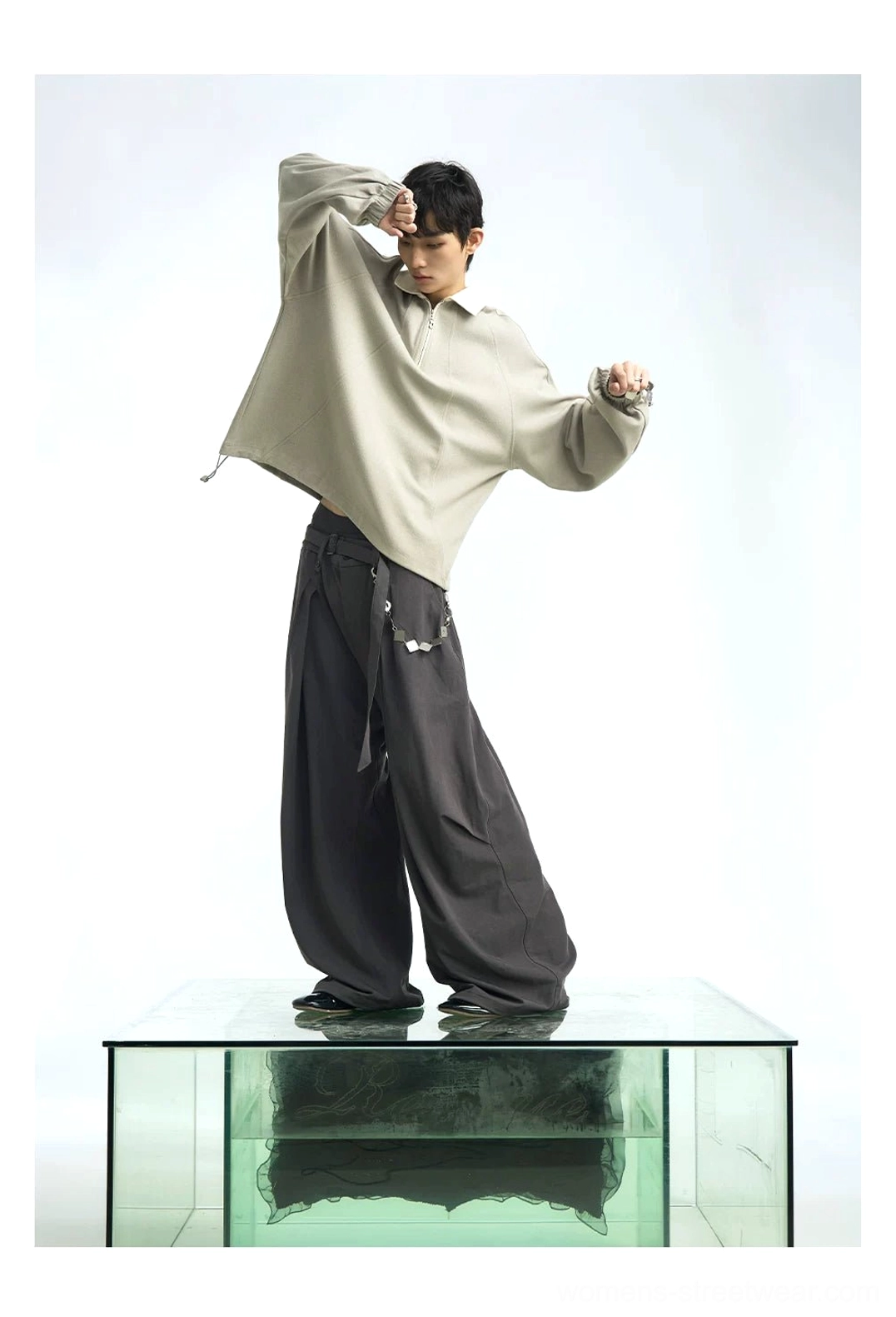 Taupe gray cropped half-zip polo sweatshirt with oversized raglan sleeves styled with wide-leg dark trousers