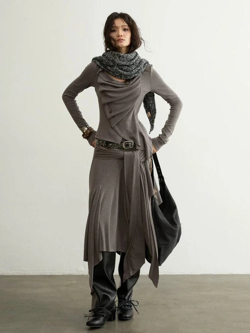 Front view of taupe Korean streetwear outfit set showing asymmetric draped torso, decorative front buttons, fitted long sleeves, wrap skirt, and wide waist belt