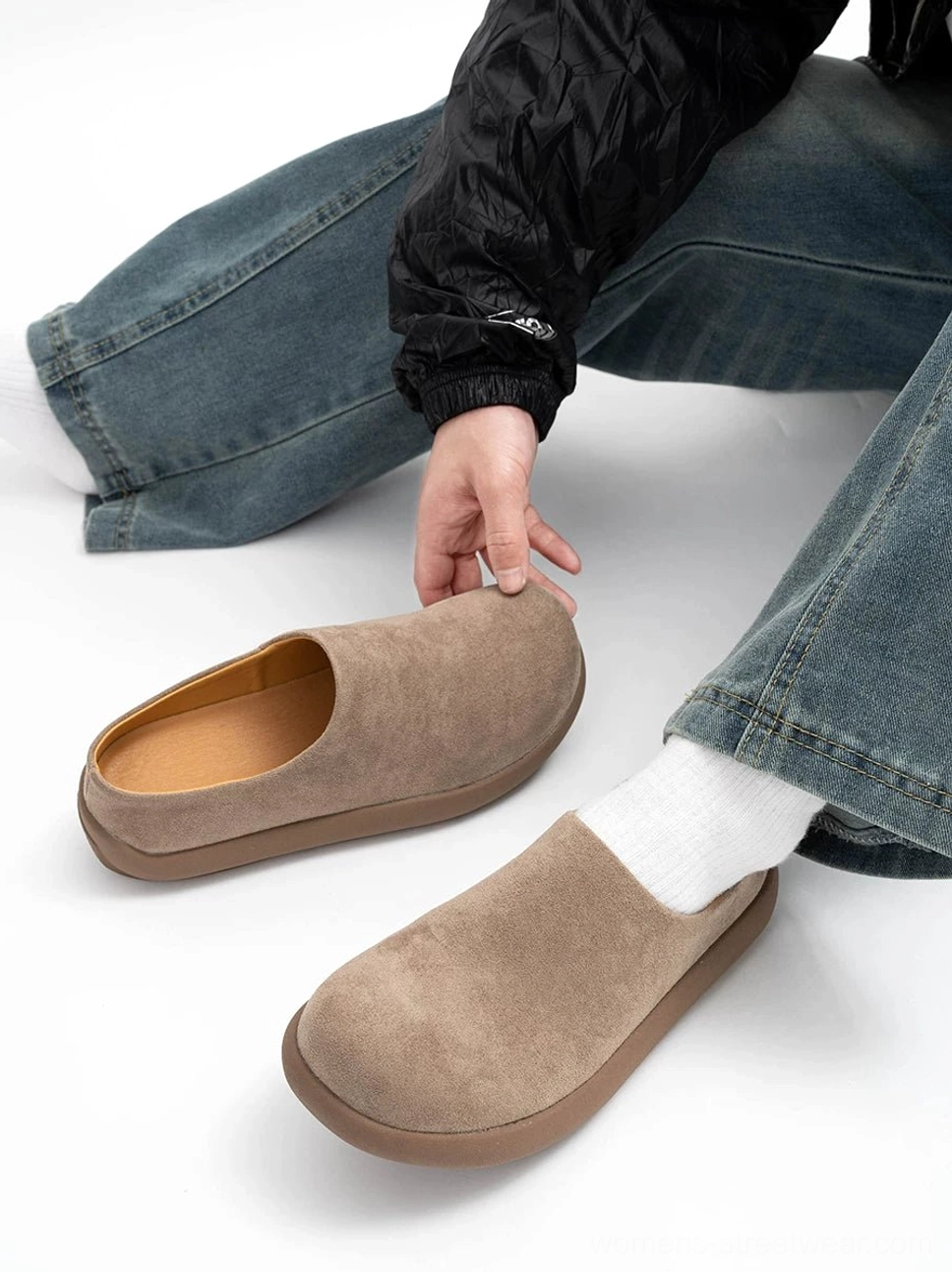 Taupe suede mule clog worn with blue jeans and white crew socks, featuring an open back, rounded closed toe, and brown rubber platform outsole