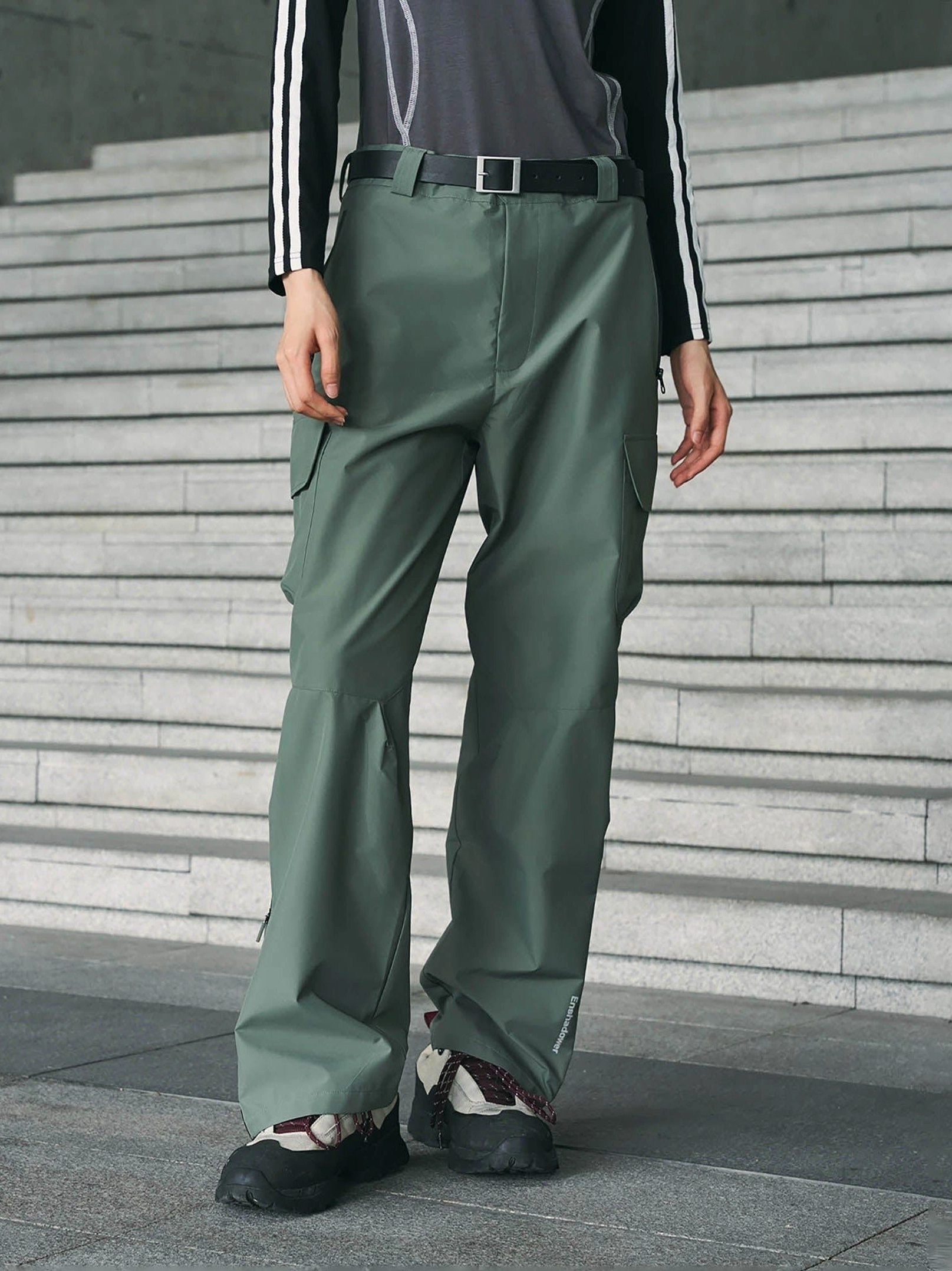 Sage green techwear waterproof cargo pants shown from the front with a relaxed straight-leg fit, thigh utility pockets, belt loops, and outdoor streetwear styling