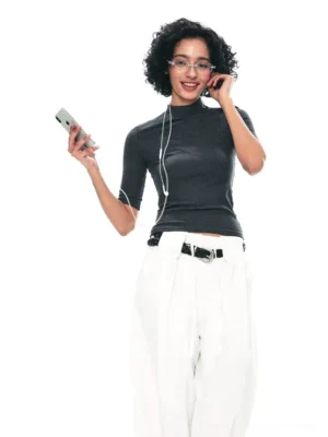 Dark gray TENCEL mock neck half-sleeve streetwear top styled with white wide-leg trousers and black leather belt