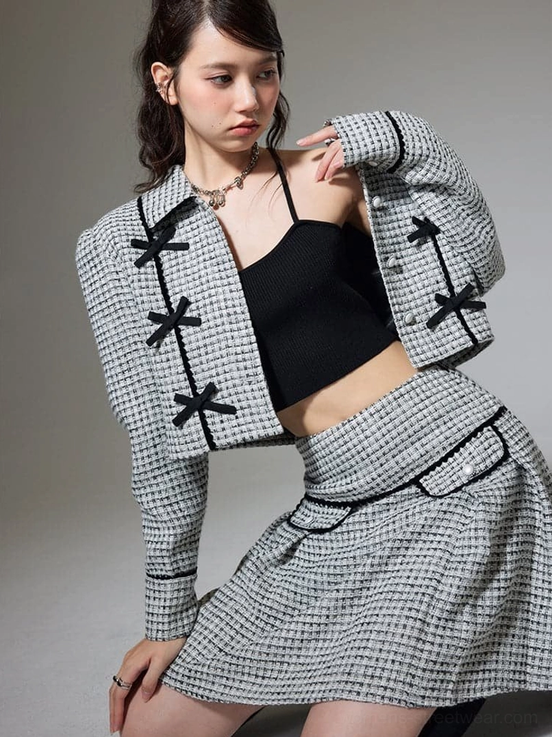 Textured cropped jacket and high waist pleated mini skirt with contrast piping and decorative bows