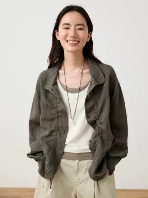 Dark gray textured Mandarin collar button-up shirt layered over a white camisole with relaxed beige shorts in a minimalist streetwear studio outfit